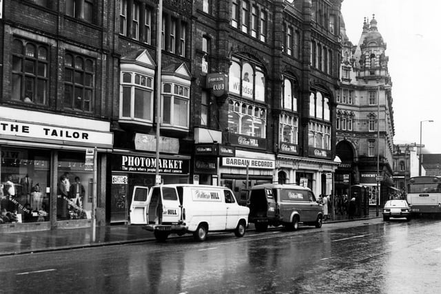 A view of Vicar Lane showing March the Tailor, Photomarket, Bargain Records and a vacant building.