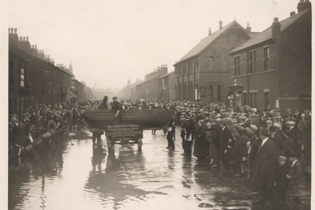Crowds watch the clean-up get underway in Blakiston Street during the 1927 floods. The large building on the right is St Margarets Church, now an apartment building