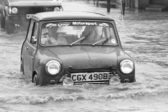 Here, one driver braves the depths of the flood in a Mini.