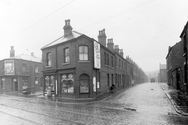 The corner shop at 208 Kirkstall Road, at junction with Metcalf Street. A woman is looking in the shop window.