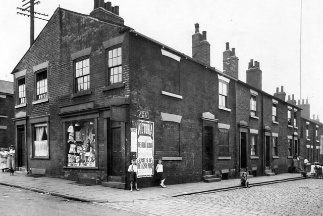 Corner of Bean Street and Great Garden Street in Burmantofts. In main view is H Levis corner shop. Children in street and group of women with a dog on another corner.