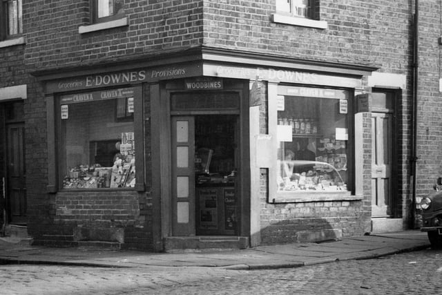 Brick-built corner shop of E. Downes at number 32 Ackroyd Street, Morley The shop sells groceries and provisions. Through the open door the shop scales are visible and there are large jars of sweets in the right hand window.