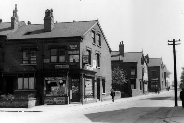 Shop on the corner of Seaforth Avenue and Foundry Lane - renamed Foundry Approach -  in Harehills. Shows advertising signs and people passing by.