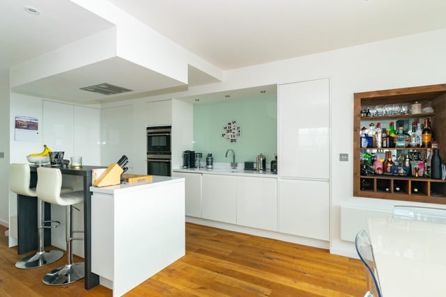 The modern kitchen has built in appliances and a bespoke kitchen island.
