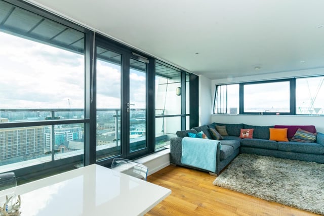 The whole living room has wall length glass windows and doors which open onto the balcony.