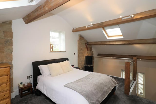 There is ample space for a large bed in this beautiful bedroom, decorated with revealed stonework, exposed beam and fitted mirror fronted wardrobes providing good hanging and storage space.