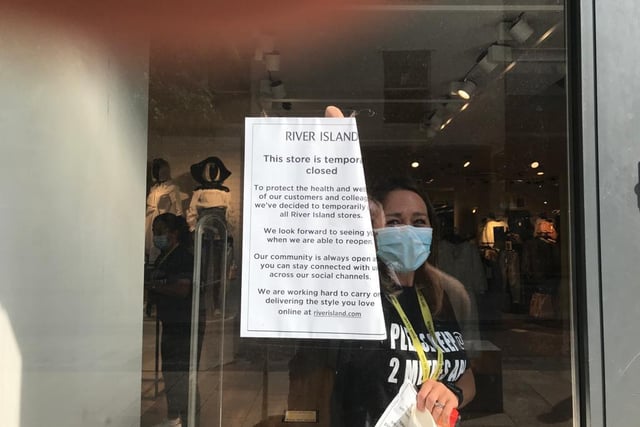 Staff at River Island taking down window signs
