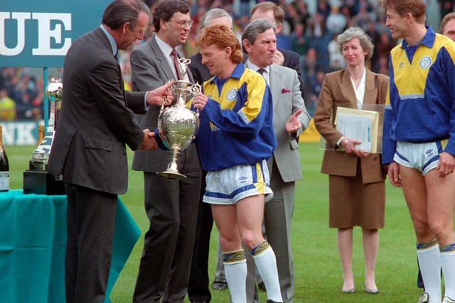 Leeds United captain Gordon Strachan gets his hands on the trophy.