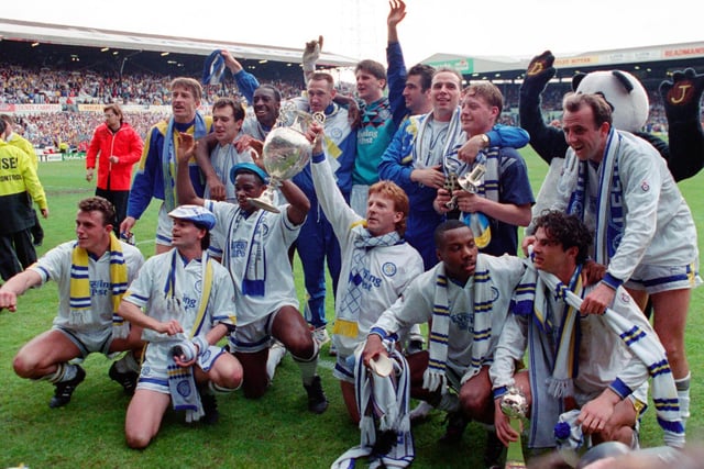 The players celebrate with First Division trophy on the pitch.