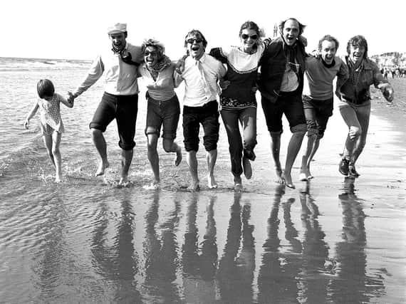 Wiganers pose for a group photograph as they have a paddle on the seafront of Blackpool during their wakes weeks holiday in 1969