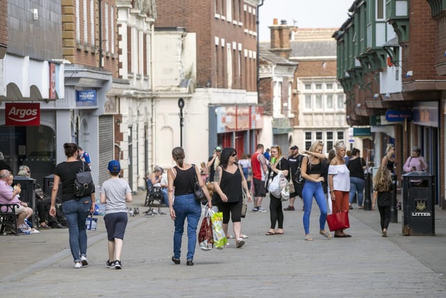 In Pontefract town centre, keen customers are seen on a busy high street.