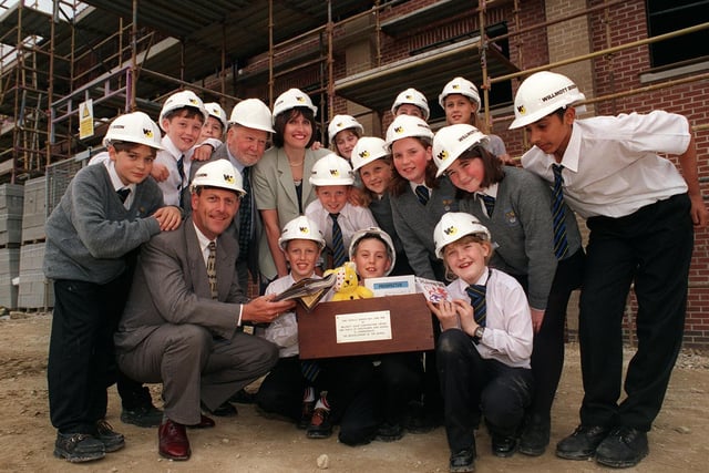 Pupils from Priesthorpe High School with a time capsule they were to bury in the foundations of a new wing. Pictured with pupils is, from left, Paul Willis, of Willmott Dixon Construction, Coun Mick Coulson and head of history Judith Hart.