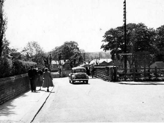 A view of railway bridge on Oxford Road, just beyond is the junction with Otley Road. To the right is Netherfield Road. A car is passing over the bridge, pedestrians are in view.