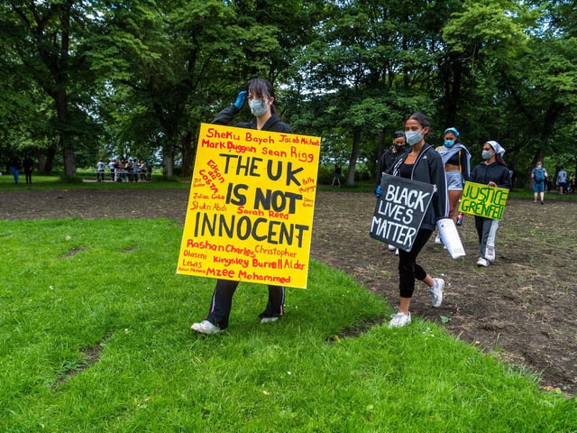 A placard with the names of black people in the UK who have died in police custody