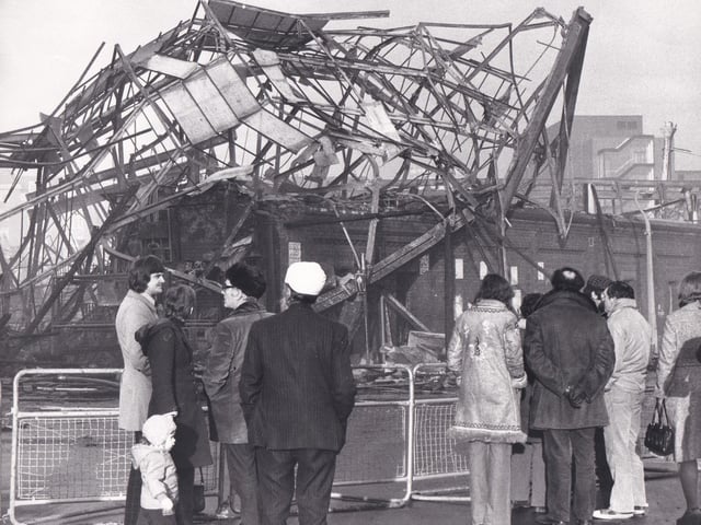 Traders and shoppers get a close up view of the charred remains and twisted metal.