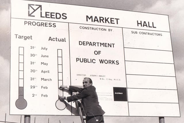 Leeds Public Works department employee Harry Blackburn updates a noval sign on Harper Street in March 1976. The sign - a pictorial progress report - gives the cheering news that the rebuilding of the fire ravaged market hall was on schedule.