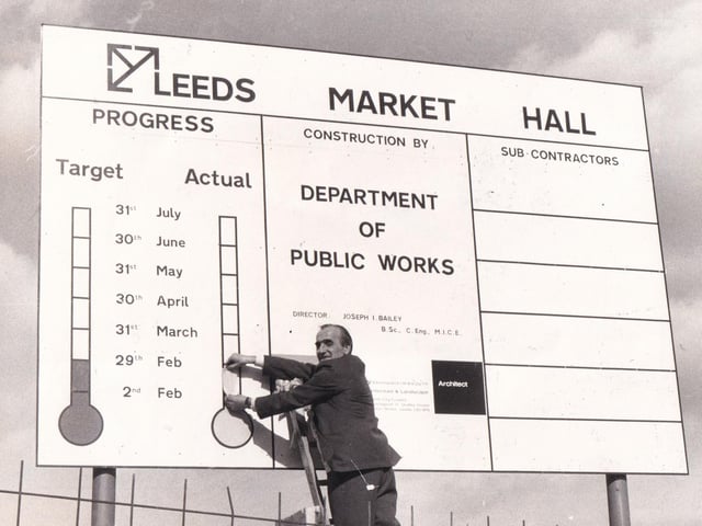 Leeds Public Works department employee Harry Blackburn updates a noval sign on Harper Street in March 1976. The sign - a pictorial progress report - gives the cheering news that the rebuilding of the fire ravaged market hall was on schedule.