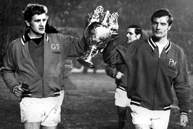 Gary Sprake and Paul Madeley parade he trophy around the Elland Road pitch.