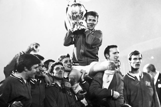 Captain Billy Bremener is held aloft by teammates as he shows off the First Division trophy.