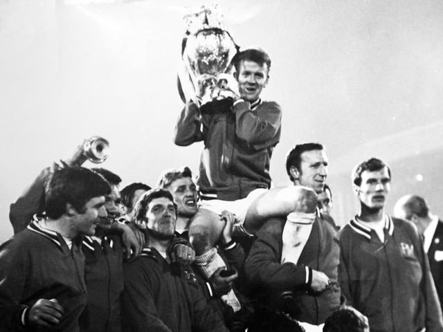 Captain Billy Bremener is held aloft by teammates as he shows off the First Division trophy.