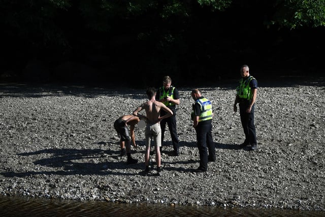 A police officers move people on at the River Wharfe in Ilkley