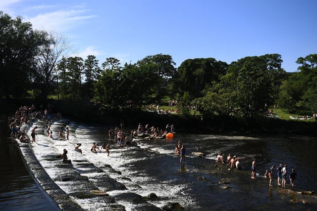 Crowds gather in Burley-in-Wharfedale as people head to the River Wharfe