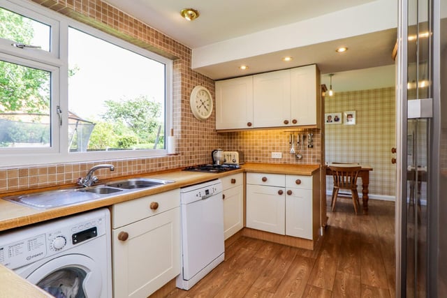 The kitchen has a  range of wall and base units with laminate work surface over and tiled splash back above, a stainless steel sink and drainer, integrated double oven and grill, four-ring gas hob and space for a tall fridge/freezer.