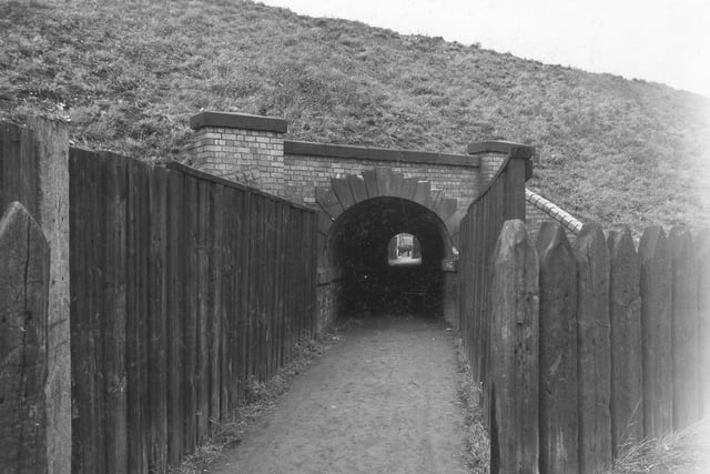 Wooden fences to left and right of a passageway leading to an underground subway underneath the Leeds, London, Midland and Scottish railway bridge on Gelderd Road, Hunslet in October 1940.
