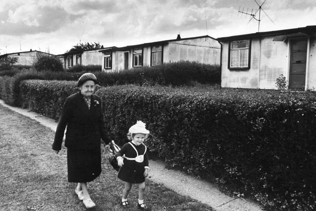 A woman and little girl walked by a row of pre-fab homes in Cottingley in July 1970. By then the residences had seen a generation grow up.