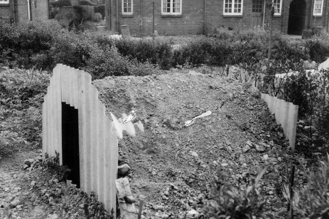 An Anderson type air raid shelter, erected in the garden of number 39 Rookwood Cresent, Osmondthorpe. The rounded roof of the shelter is being covered with earth.