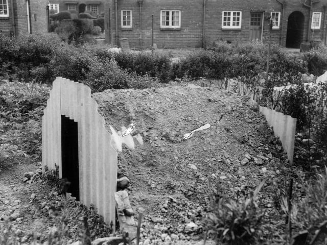 An Anderson type air raid shelter, erected in the garden of number 39 Rookwood Cresent, Osmondthorpe. The rounded roof of the shelter is being covered with earth.