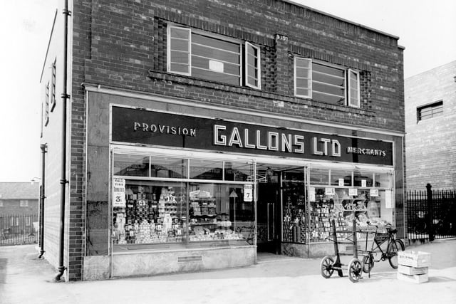 VIew of Gallons Ltd grocerss on Selby Road. Double fronted premises with provisions displayed in windows. Delivery bicycle can be seen on pavement outside