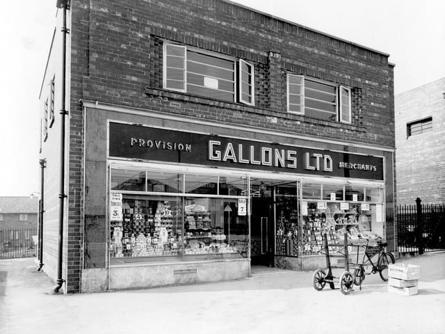VIew of Gallons Ltd grocerss on Selby Road. Double fronted premises with provisions displayed in windows. Delivery bicycle can be seen on pavement outside