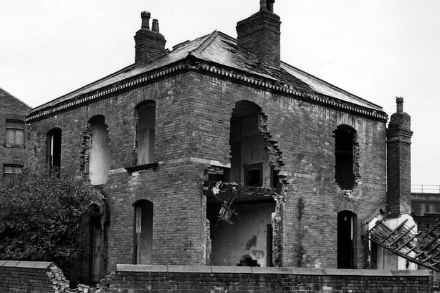 A view of Bath House, a large, brick built, square detached property shown here in the process of demolition.