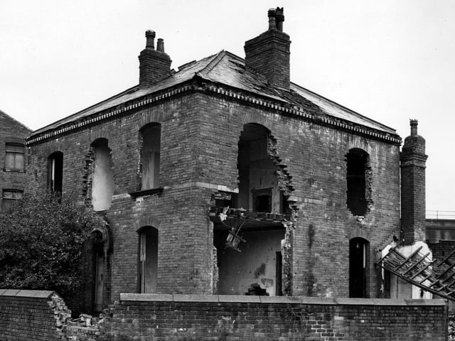 A view of Bath House, a large, brick built, square detached property shown here in the process of demolition.