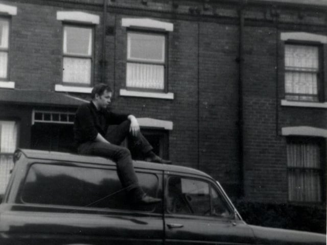 View of Colenso Grove showing a man sitting on top of a Ford Anglia van.
