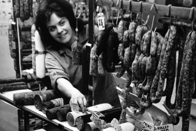 This is trader Moya Underwood, surrounded by imported food on Kirkgate Market