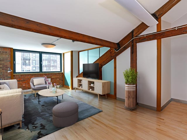 The open plan living space has extensive beams, vaulted ceilings and exposed structural features. (Virtually staged living space)