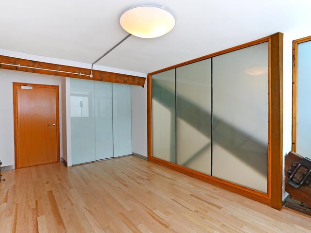 The master bedroom is full of character - including extensive exposed beams, sloping ceilings.