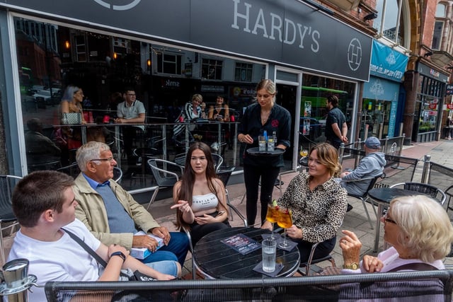 A group of people who have prebooked are been served drinks by a waitress at Hardy's bar on New Briggate.
