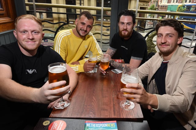 CHEERS: from left, Jordan Taylor, Jake Cheetham, Aaron Swift and Daniel Jones  enjoy their first pint in a pub since lockdown, at The Moon Under Water, Wetherspoon pub, Wigan.