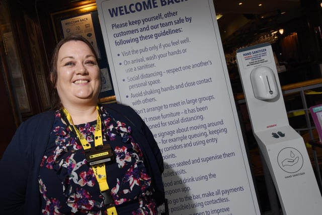 Vickie Greenough greeting customers, explaining safety measures  at The Moon Under Water, Wetherspoon pub, Wigan.