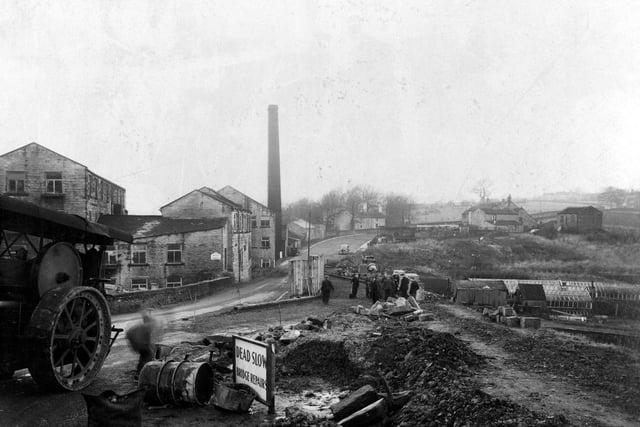View of bridge repairs in Roker Lane showing workmen and equipment including part view of a traction engine. On the left is a factory building with a tall chimney.
