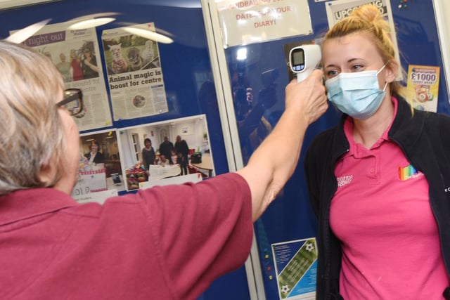 Staff member Phillipa Astley gets her temperature checked before she starts work.