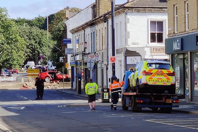 A police vehicle is mounted onto the back of a recovery truck in Bradford Road.