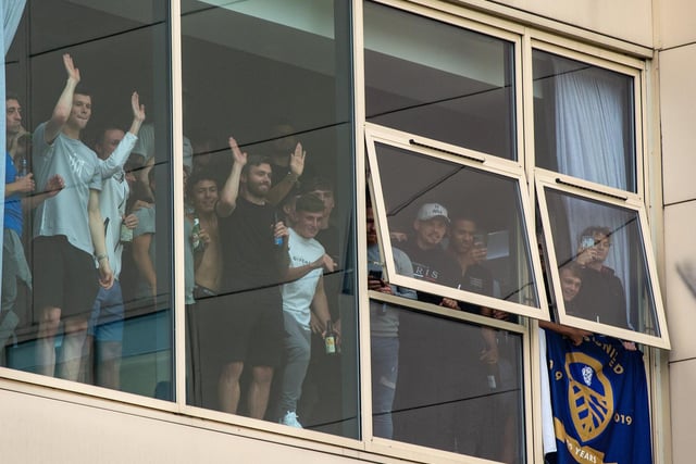 Players watch the celebrations from the window of the East Stand