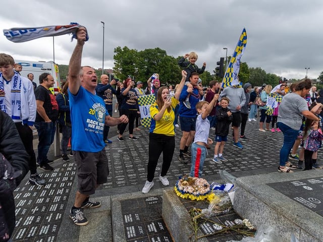 Fans singing songs at the Billy Bremner statue as Leeds were confirmed as champions.