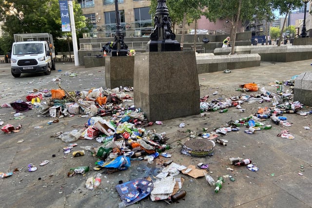 Many bottles and cans are strewn across the square.