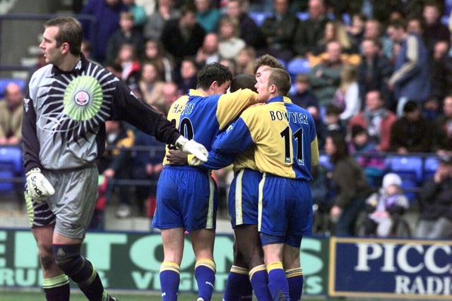 Ian Harte and Lee Bowyer hug Jimmy Hasselbaink after he beat Bolton keeper Keith Branagan (left) to score Leeds United's third goal.