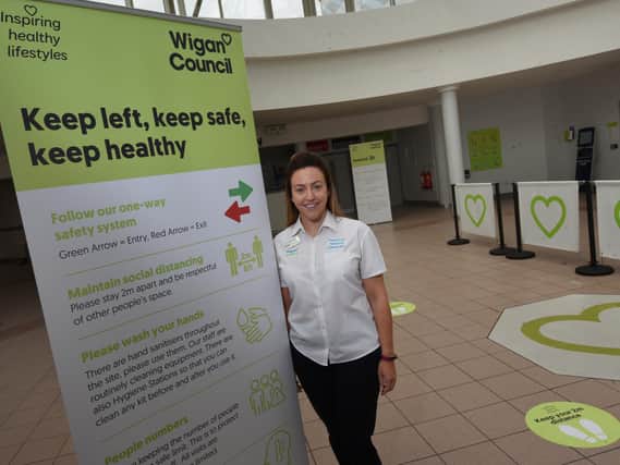 Sarah Scotson from Inspiring Healthy Lifestyles with some of the new signs detailing the new measures at Robin Park Leisure Centre.